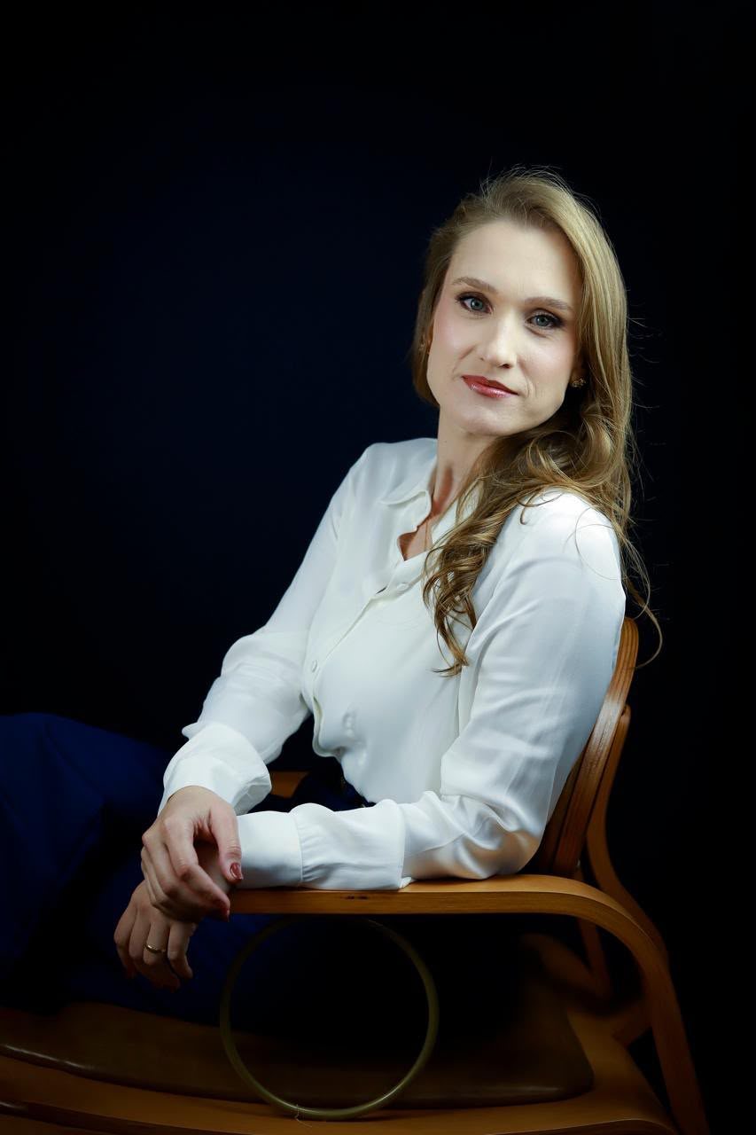 Dra. Sarah de camisa branca, sentada