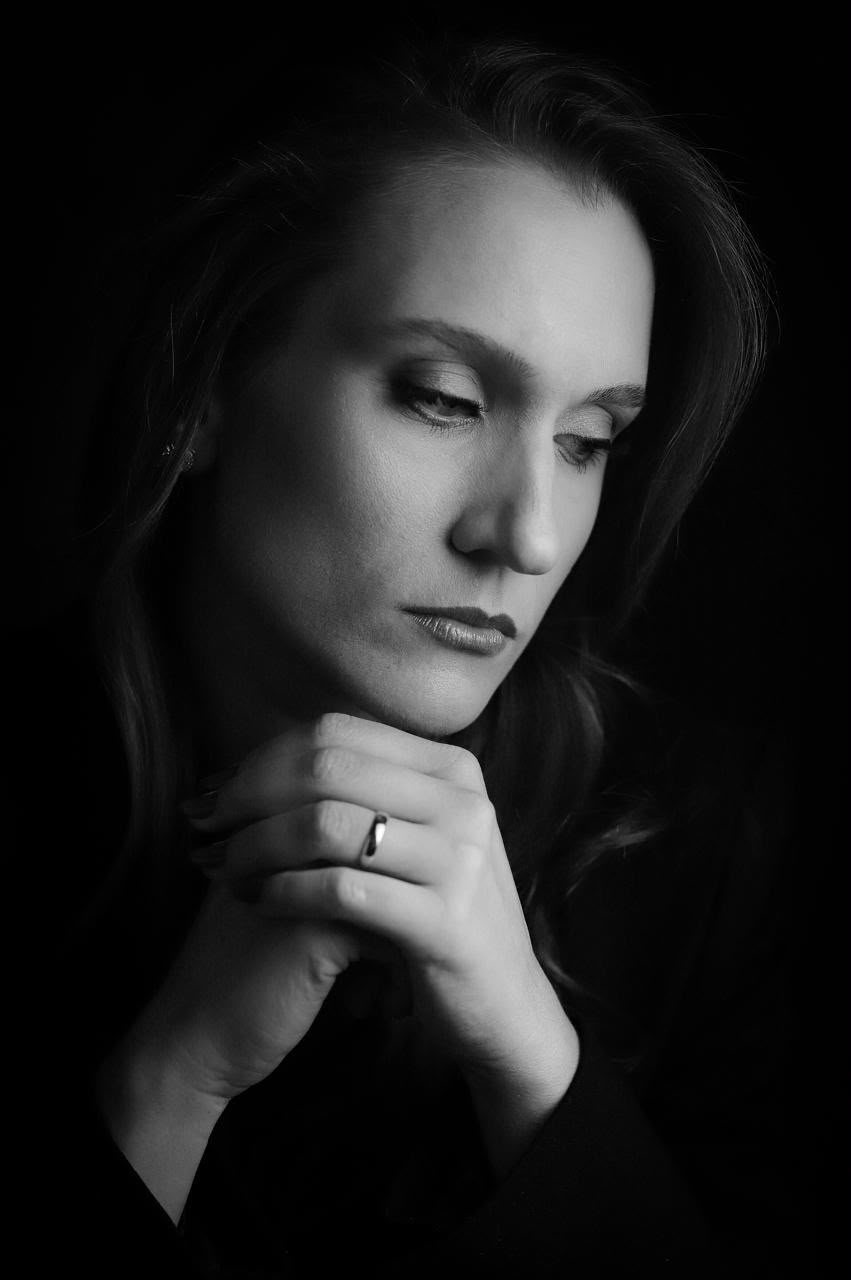 Retrato em preto e branco da Dra. Sarah, mãos apoiadas sob o queixo